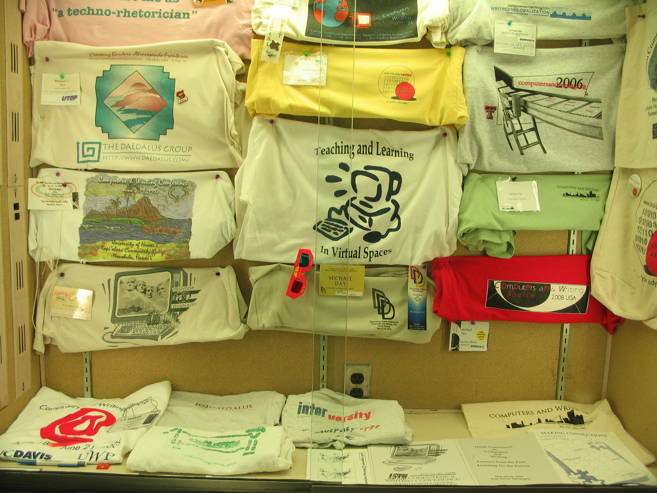A picture of a display case with CWC tee shirts displayed from the 2010 Computers and Writing Conference