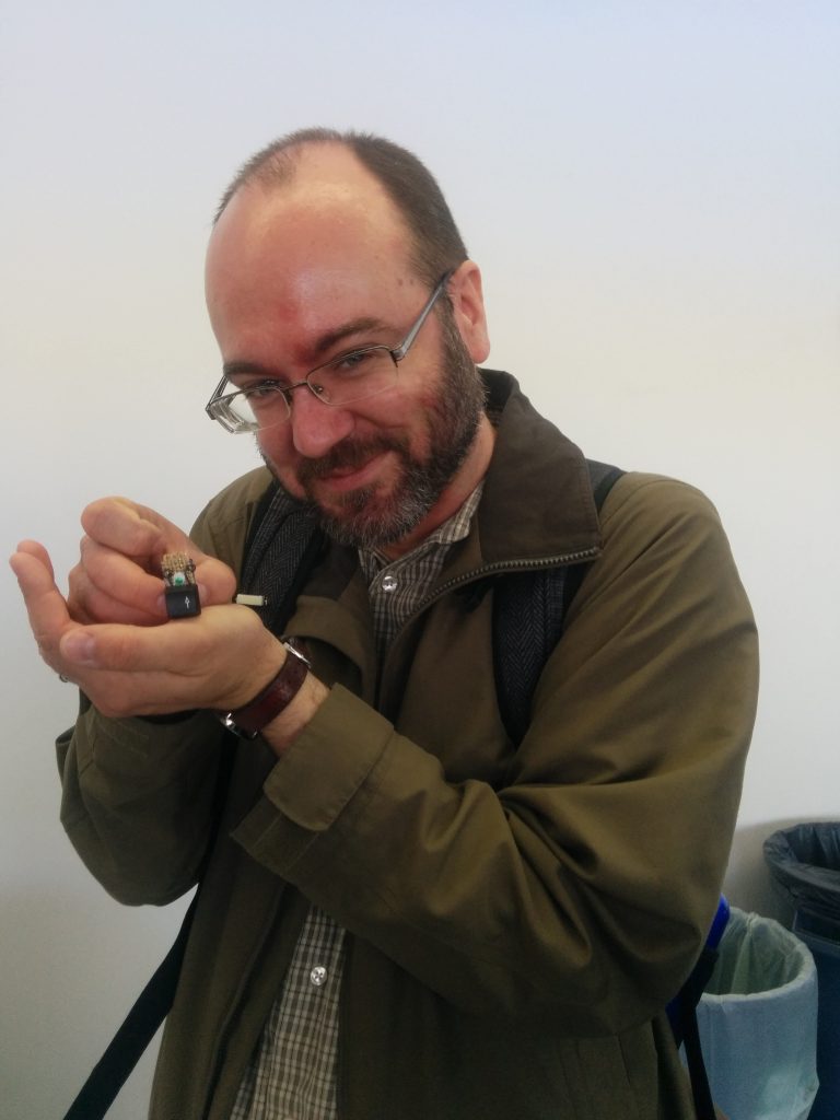 Stedman holds a small computer key with glued on eyes and with a pin backing to wear.