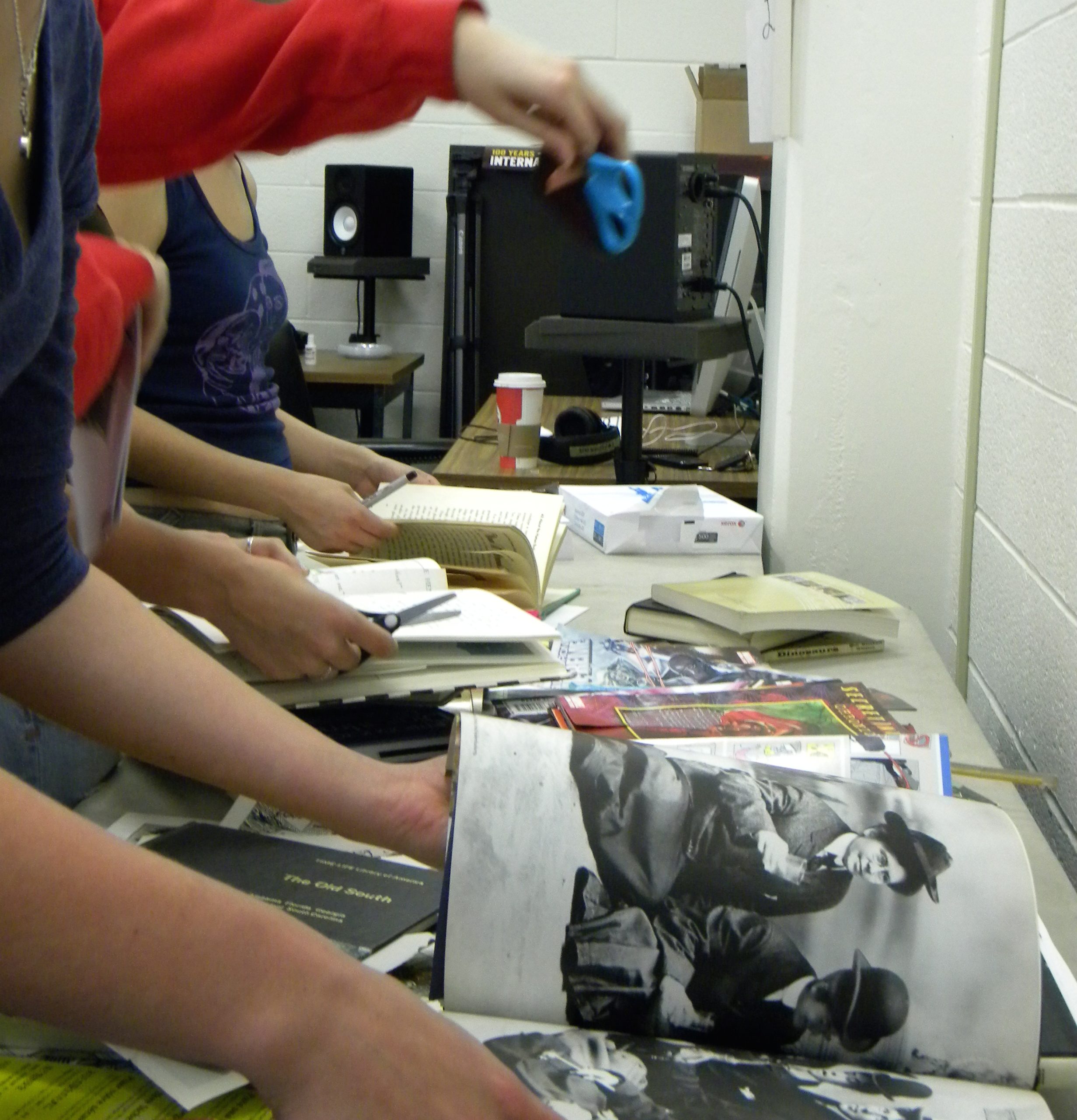 Students cutting up used books at a zine workshop, 2012