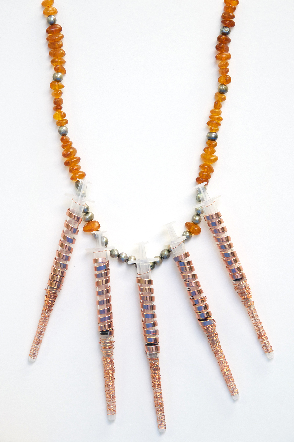 A necklace containing amber beads and syringes.