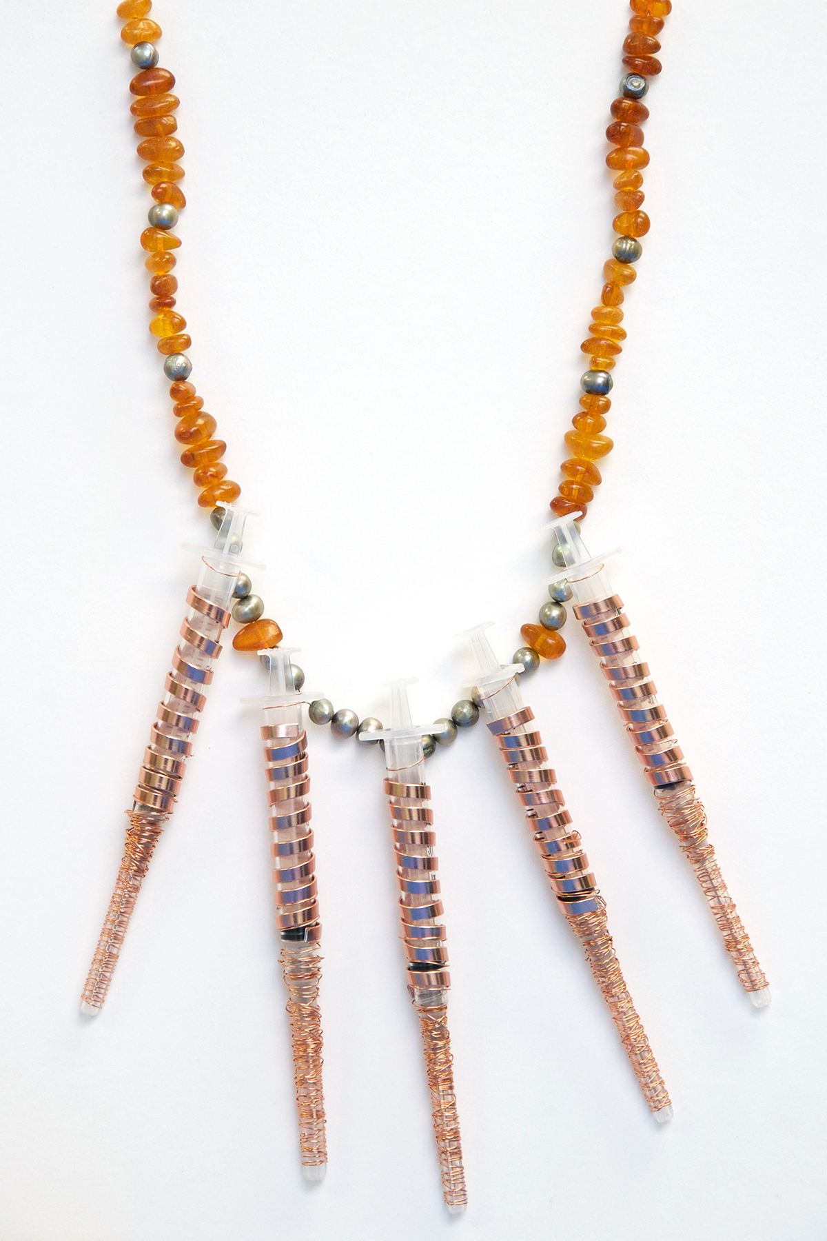 A necklace containing amber beads and syringes.