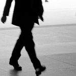 black and white image of lower body of person walking