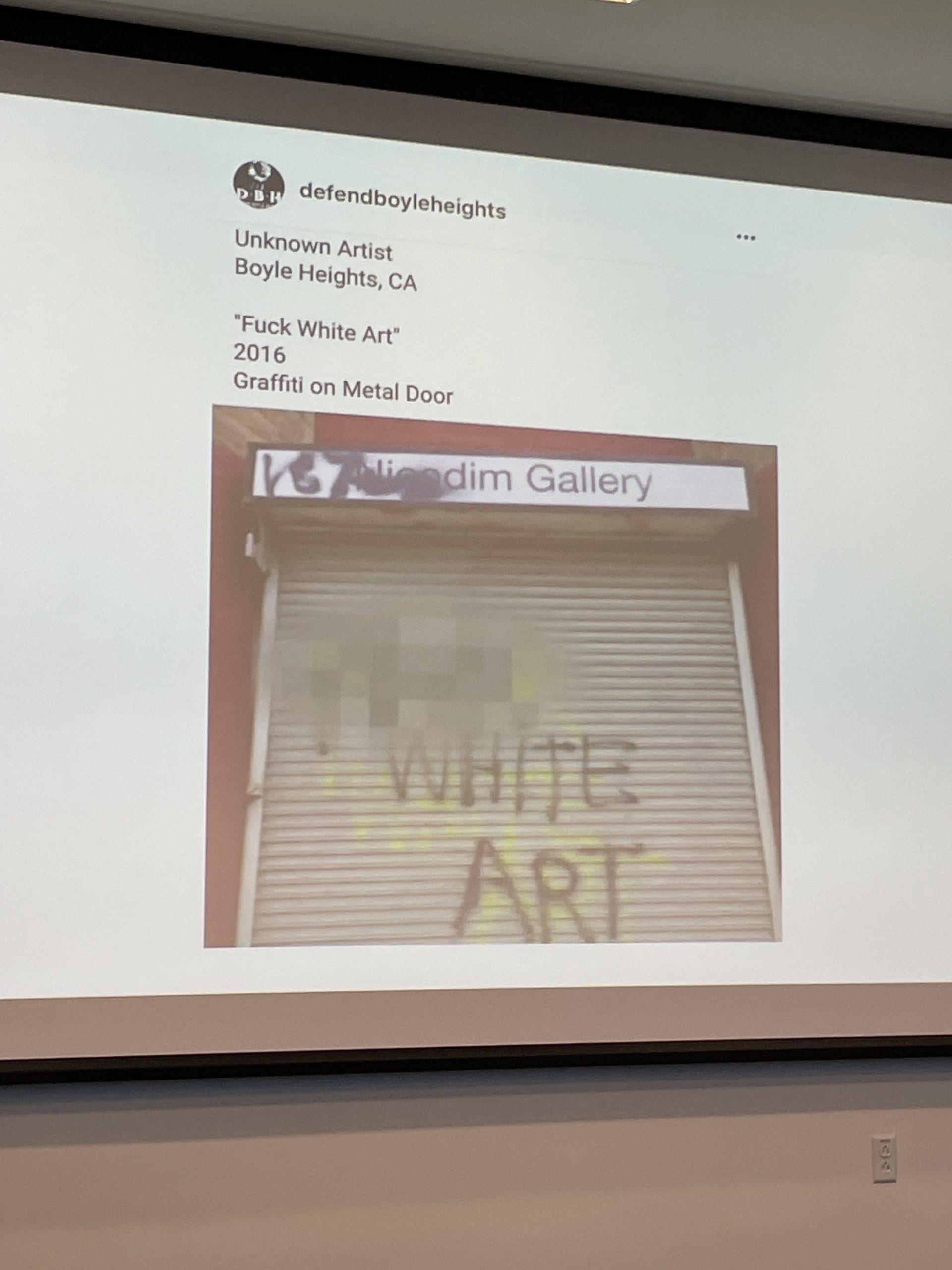 Dighton’s slide shows a tweet whose author subverts the genre of exhibition to resist gentrification. The author uses wall text, “Unknown Artist, Boyle Heights, CA, “Fuck White Art,” 2016, Graffi on Metal Door” to assign meaning to the image.